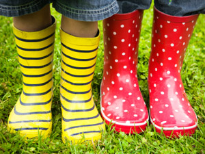 Els peus de dos infants calçats amb botes d'aigua estampades