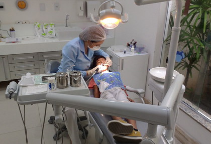 Una odontòloga atén un infant