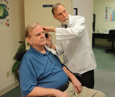 Un professional sanitari observa l'orella d'un pacient
