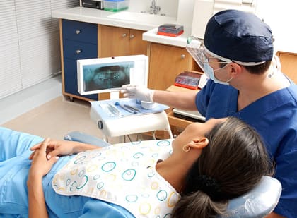 Un odontòleg revisa una radiografia amb una pacient