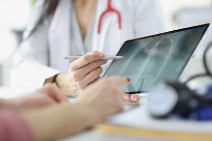 Una metgessa ensenya la radiografia de tòrax a un pacient des d'una tauleta