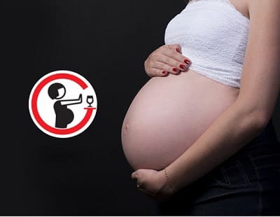 La panxa d'una dona embarassada de perfil i una icona que representa el rebuig del consum d'alcohol durant l'embaràs