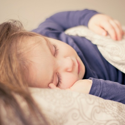 Una nena dorm plàcidament al seu llit