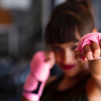 Una noia fa boxa amb uns guants de color rosa