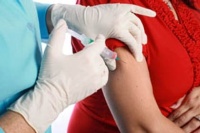 Les mans d'un professional sanitari amb guants administrant una vacuna al braç d'un infant