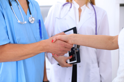 Un professional sanitari dona la mà a una pacient