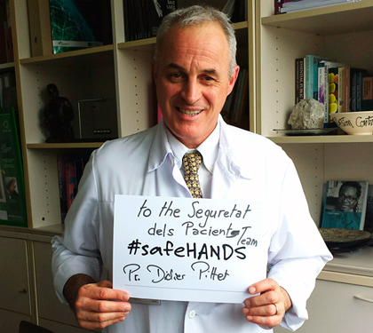 Un doctor sosté un cartell on s'hi pot llegir: To the Seguretat dels Pacients team #safeHANDS" i la seva signatura