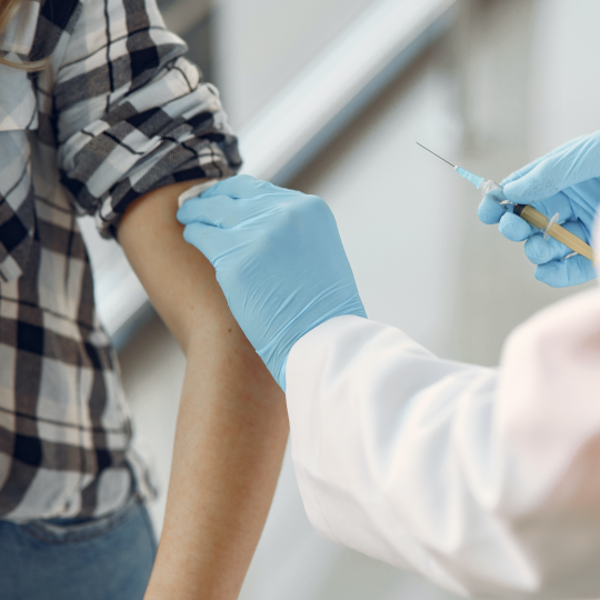 Metge o metgessa neteja el braç d'una pacient que ha de ser vacunada