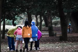 Un grup d'adolescents i una persona adulta en una parc estan en grup i parlant