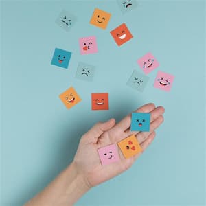 Un mà amb diversos papers que simulen cares amb emocions diverses.