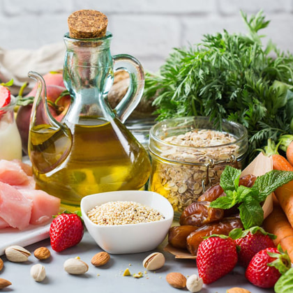 Diversos aliments que formen part d'una alimentació saludable damunt d'una taula: oli d'oliva, fruita seca, hortalisses, etc.