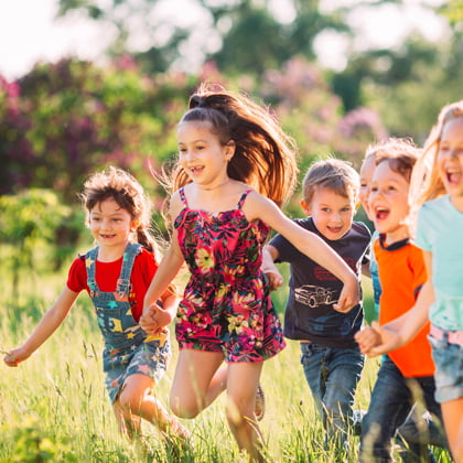 Un grup d'infants corre a l'aire lliure