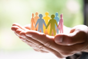 Una mà sosté figures de paper, en forma de persones, que formen una rotllana
