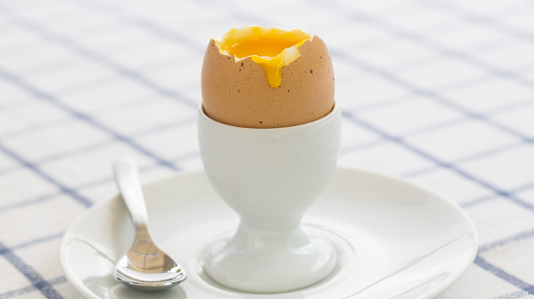 Un ous escalfat damunt d'una taula preparat per consumir