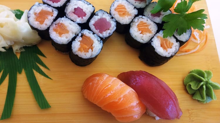 Diferents tipus de sushi i sashimi damunt d'una fusta