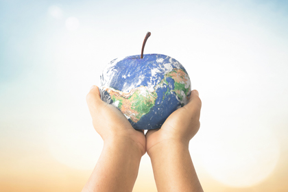 Dues mans sostenen la terra com si fos una poma