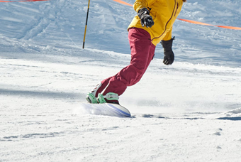 Un noi practica surf de neu en una pista d'esquí