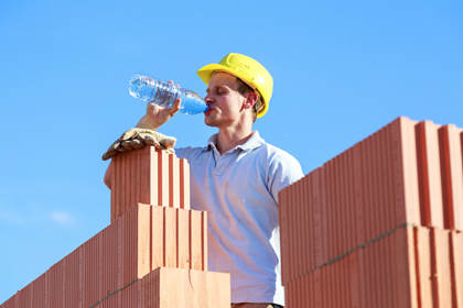 Un treballador de la construcció beu aigua durant la jornada laboral