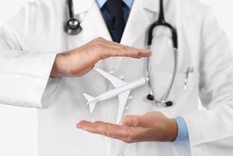 Les mans d'un metge sostenen un avió de joguina